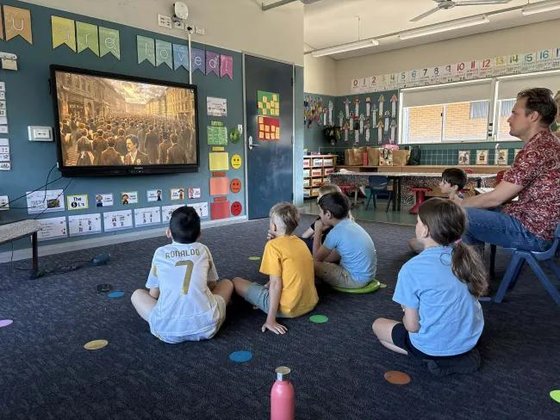 Primary school class watching a film together on a classroom screen